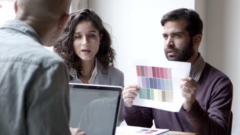 diseñadores serios mirando la paleta de colores