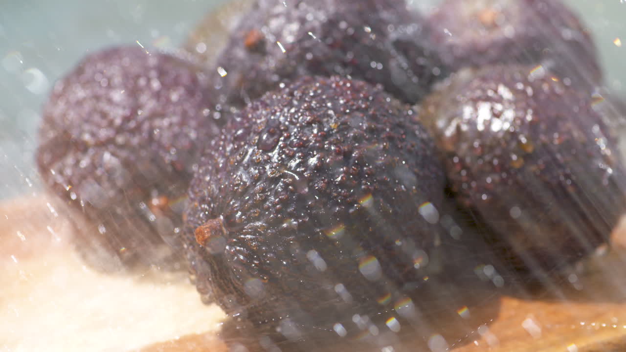 enjuagar un montón de aguacates maduros recién recogidos bajo el sol de verano