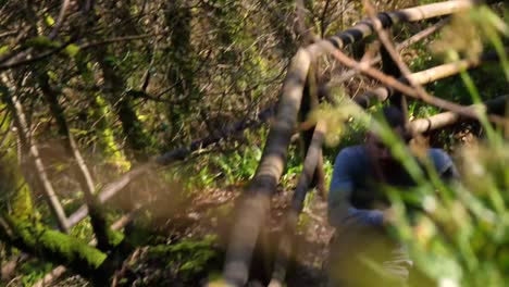 MEDIUM-SHOT-SLOW-MOTION-man-running-up-a-forest-path