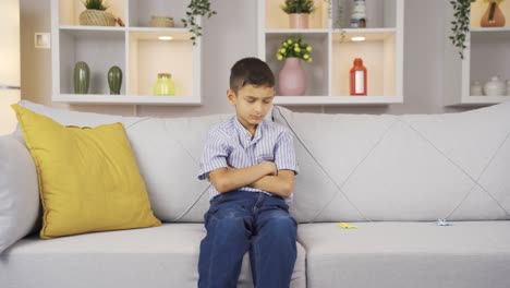 el chico mira a casa con una expresión infeliz.