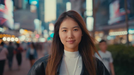 young asian woman on a bustling city street at night