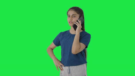 una adolescente india seria hablando con alguien en la pantalla verde de la llamada