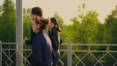 two women and one sporty man are running together along road in morning jog for healthy lifestyle