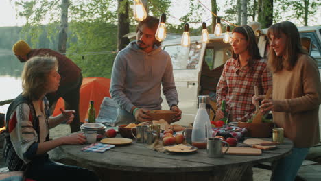 young tourists preparing food together at campsite