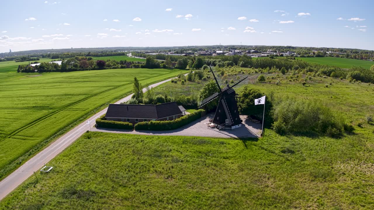 Aerial view of lush green farmland meeting the sea under a cloudy sky