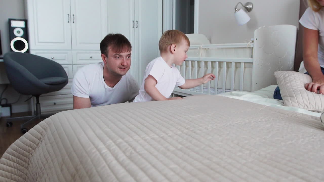 Family spending free time at home. Cheerful family having fun with their daughters on the bed