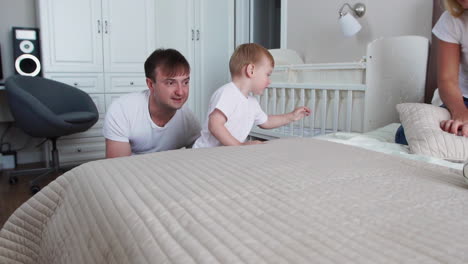 family spending free time at home. cheerful family having fun with their daughters on the bed