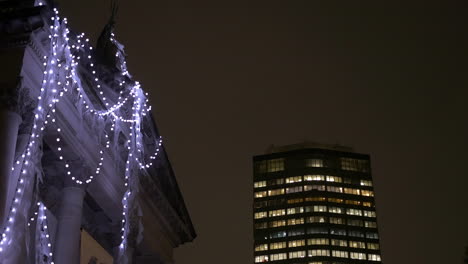 strand of christmas lights hang on the facade of a historic art museum in london uk