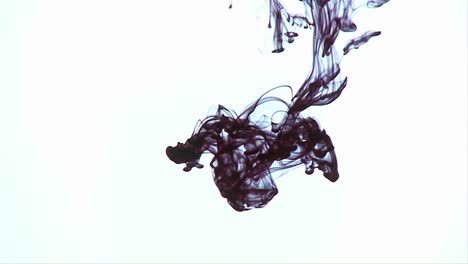 una tinta de color oscuro se vierte en un líquido y se esparce lentamente
