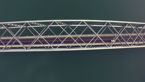 4k aerial birds eye overhead top down panning view of the adomi bridge on the volta lake also known as volta river, atimpoku, ghana, west africa with cars driving over the bridge