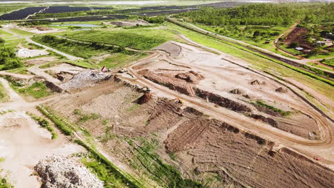 drone flying towards landfill site as camera slowly tilts down