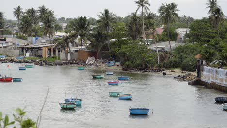 Fishing-town-in-vietnam-with-number-of-beautiful-round-shape-boat-sailing-in-water-with-the-view-of-village-in-the-background