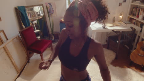 creative black girl performing energetic dance at home
