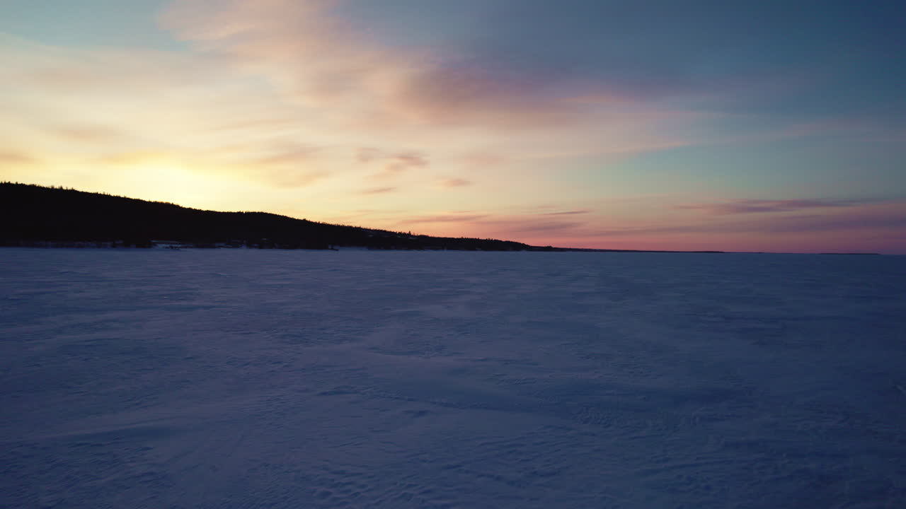 Drone in volo sopra un lago ghiacciato in Canada all'ora d'oro