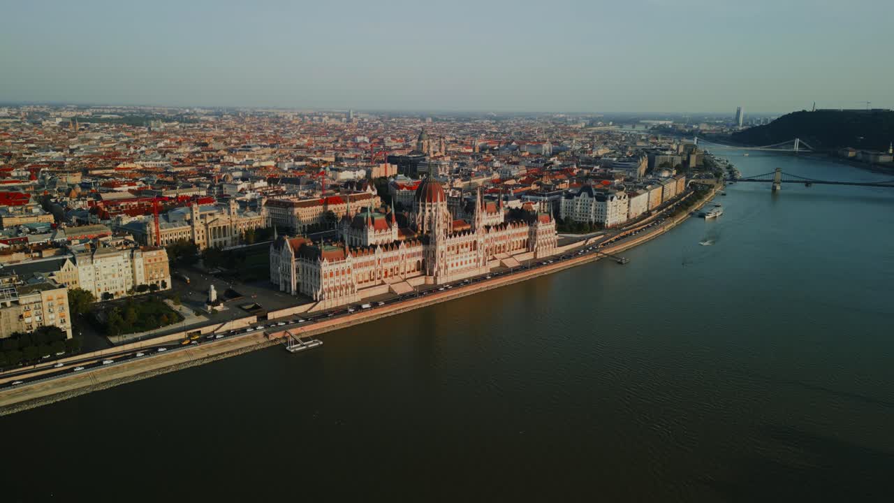 Aerial establishing of Budapest Parliament and Danube River with city skyline at golden hour