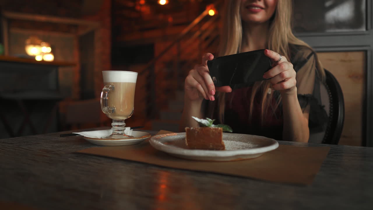 hermosa chica feliz emocional está haciendo una foto de la comida en la cafetería, café con leche en la mesa, postre helado pastel de chocolate menta cereza, comunicación en las redes sociales