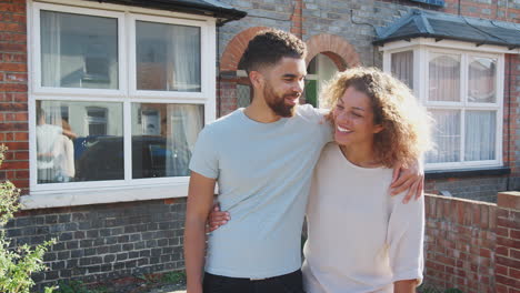 Portrait-Of-Young-Couple-Standing-Outside-New-Home-In-Urban-Street