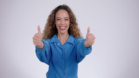 Thumbs-up,-face-and-woman-in-studio-with-smile