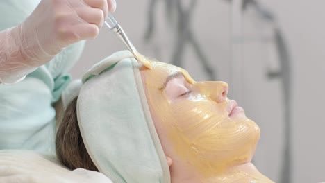 professional face care procedures in the modern cosmetology clinic. beautician is doing face treatment procedures - purification, mask, peeling, carboxytherapy