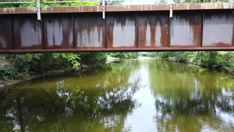 Una-Mirada-Debajo-De-Un-Puente-De-Metal-Y-Piedra-Sobre-El-Río-De-Cedro-Rojo