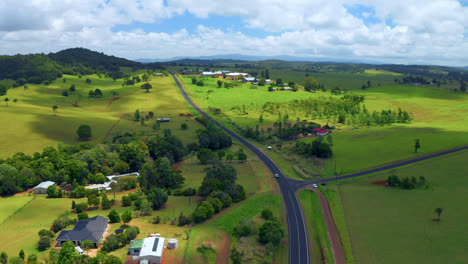 vehicle traveling on scenic country road in atherton tablelands, queensland, australia - aerial drone shot