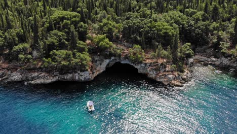 Kleines-Boot-In-Der-Nähe-Der-Felsigen-Küste-Mit-üppiger-Vegetation-Am-Strand-Von-Foki-In-Kefalonia,-Griechenland