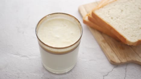 Glass-of-whole-cream-milk-on-table-,