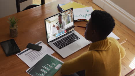 african american female teacher having a video call with male college student on laptop at home