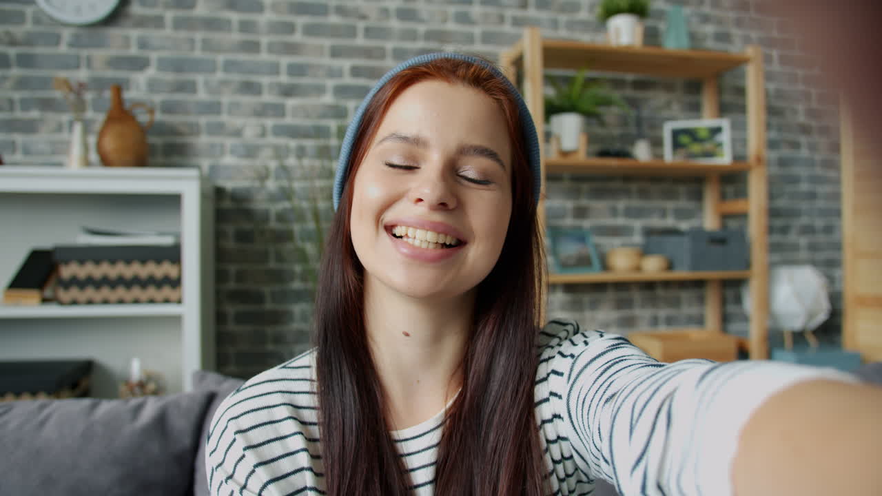 una mujer tomando una selfie en casa.