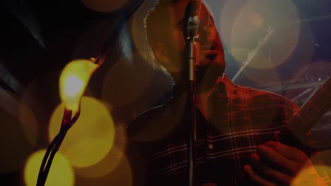 punto brillante de luces contra el hombre cantando en un concierto