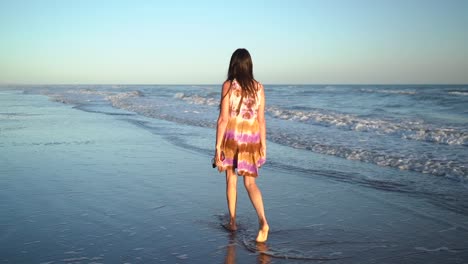 woman in dress walking on the beach - wide shot