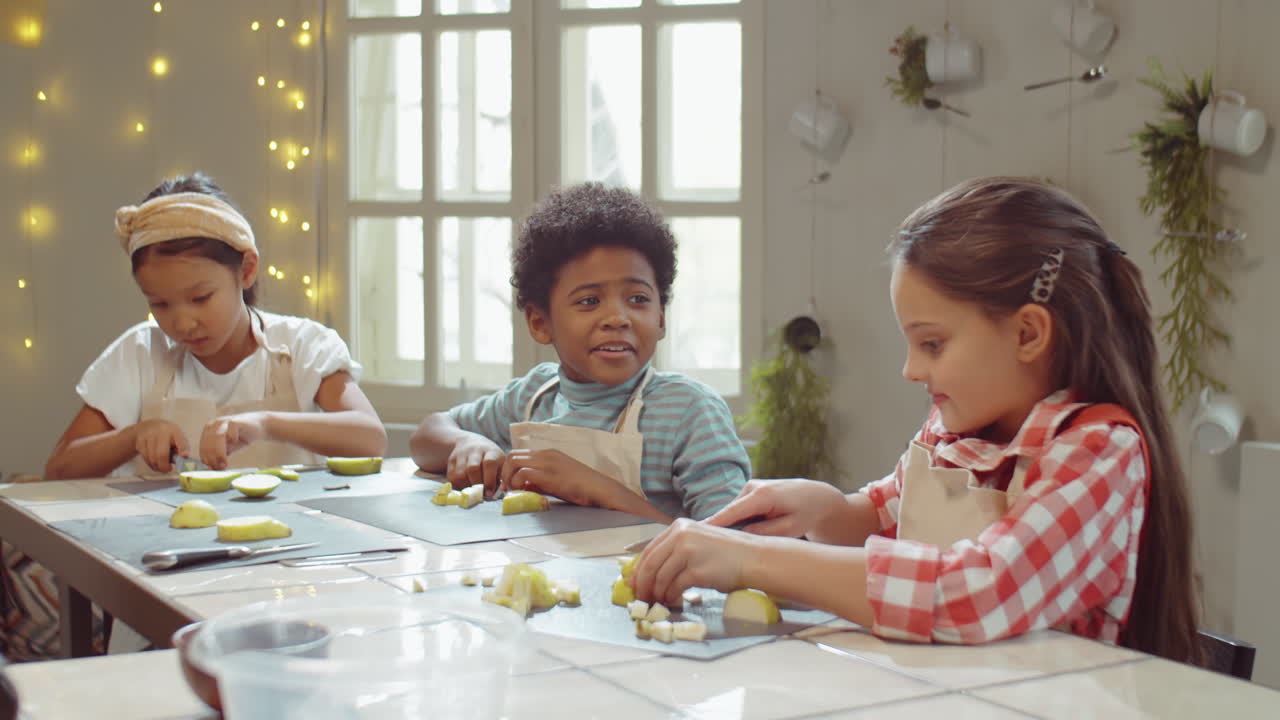 Bambini piccoli che tagliano pere a una masterclass di cucina