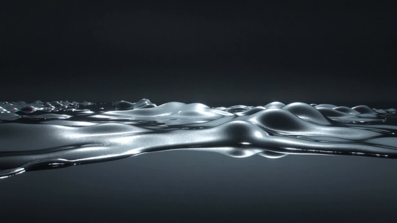Starter simulering, metallisk flytende plate danner buler og fordypninger som viser refleksjoner i studio.