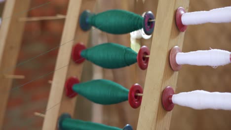 primer plano de algodón de seda de pluma instalado en una máquina mecánica de tejer de madera