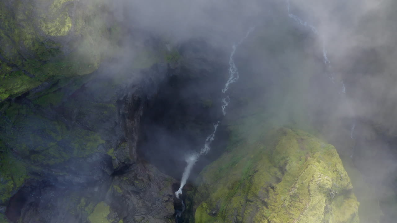 Top down aerial drone shot of deep Mulagljufur canyon Wirth misty, foggy cloud, and green moss in Southern Region in Iceland