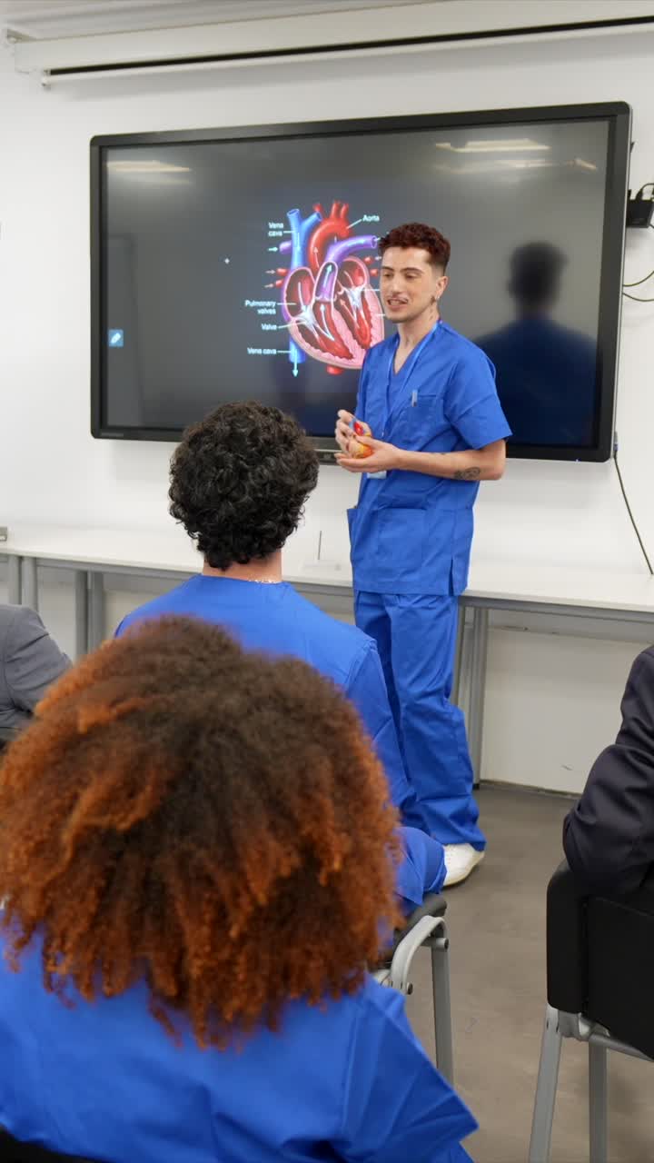 Estudiante de medicina explicando la anatomía del corazón humano en una pantalla interactiva