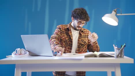 un joven estudiante guapo se alegra y disfruta estudiando.