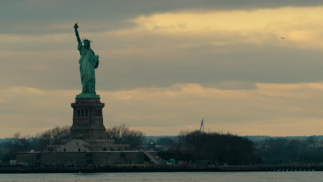 statue of liberty, framed left, with colorful evening sky