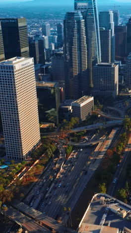 complicated road systems and junctions between the stunning skyscrapers. crazy traffic in the downtown of los angeles. aerial view. vertical video