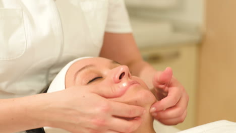 therapist doing a facial massage at beauty spa