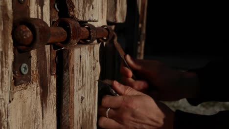 closing an old wooden door from exterior close up