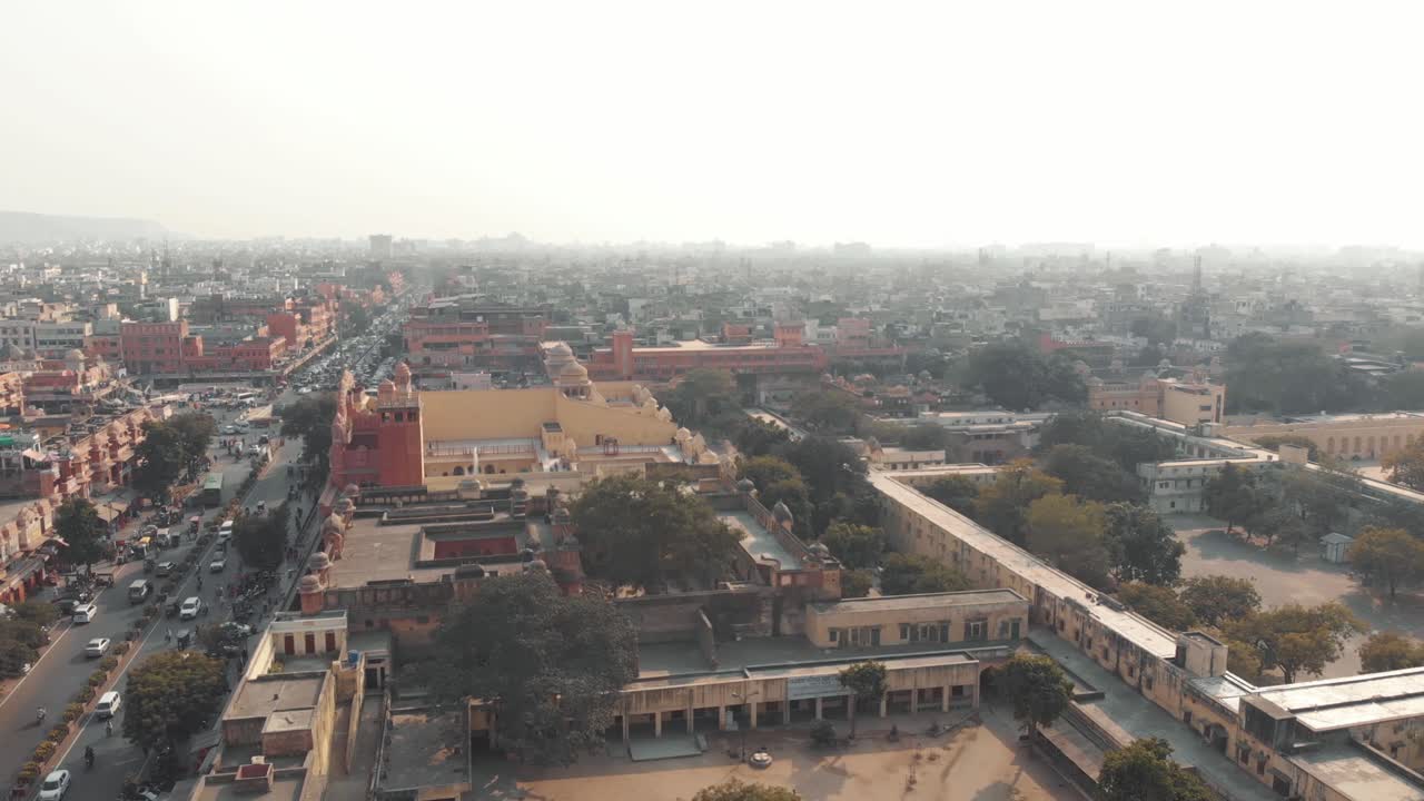 Misty cityscape of Jaipur in busy traffic roads on a sunny morning in Rajasthan, India - Aerial Slide Fly-over shot