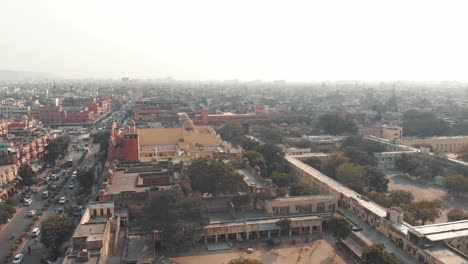 brumoso paisaje urbano de jaipur en concurridas carreteras de tráfico en una mañana soleada en rajasthan, india - toma aérea de sobrevuelo