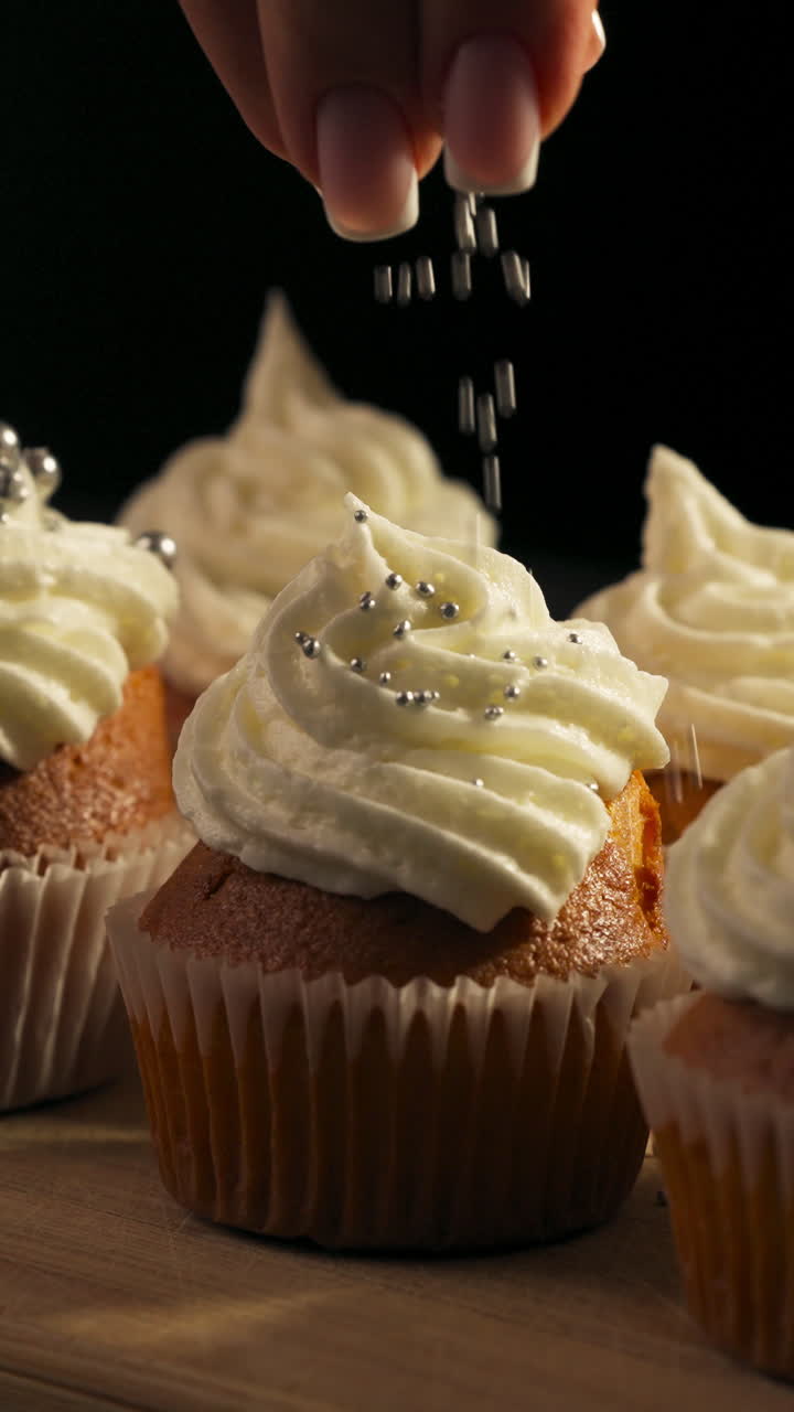 Vista Verticale Di Un Cupcake Gourmet Con Glassa Bianca E Perle Di Zucchero Lucide. Scatto Ravvicinato