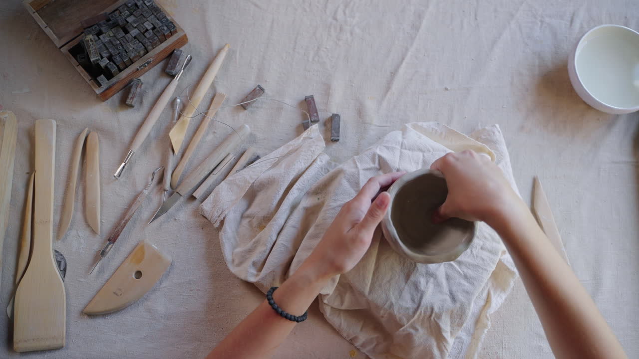 persona que da forma a un cuenco de arcilla