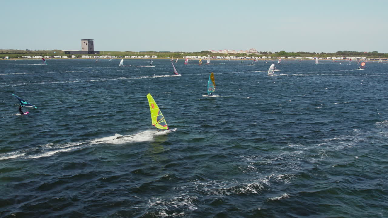 turistas haciendo windsurf en el lago grevelingen cerca de port zeeland, zelanda, países bajos