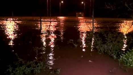 nighttime flooding with streetlight reflections on water