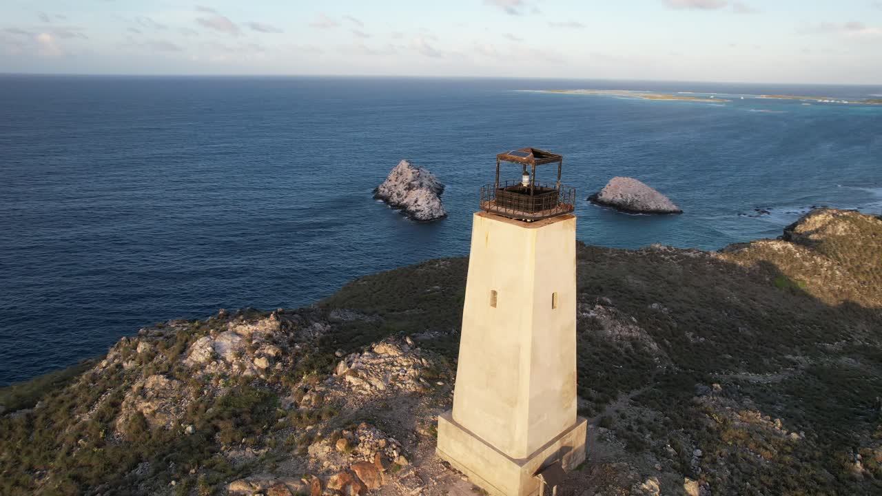 faro holandés en los rocas, mostrando paisajes serenos al atardecer, vista aérea