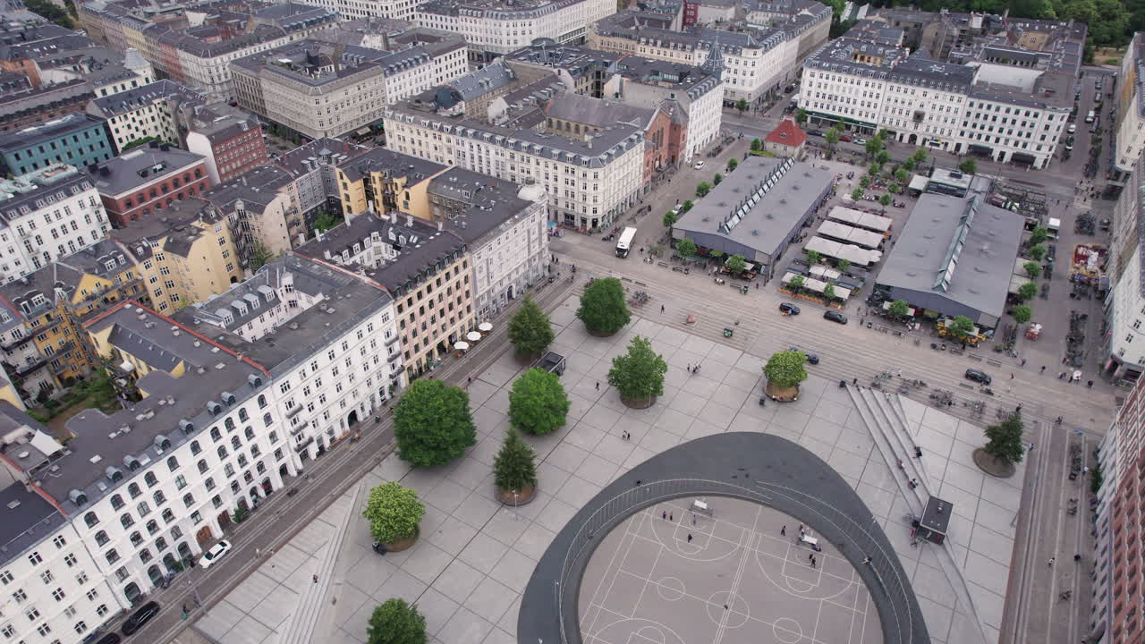 una toma aérea captura la animada atmósfera de israel platz en copenhague durante el día, con multitudes de personas y un paisaje urbano vibrante