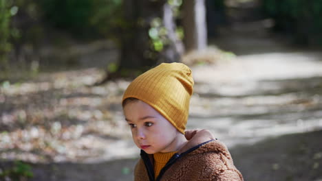 caucasian kid running in the autumn park. lovely baby boy having good time in nature on sunny day.
